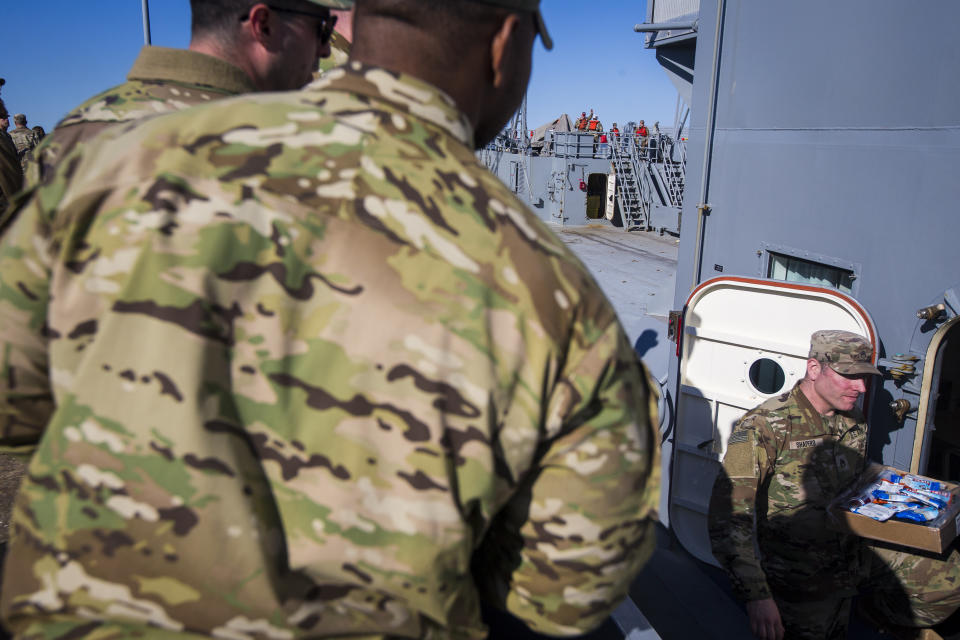 Soldiers give the crew of the LLV Monterey a box of snack bars before the Monterey leaves for deployment to the Gaza Strip for a humanitarian mission on Tuesday, March 12, 2024, at Joint Base Langley-Eustis in Hampton, Va. (AP Photo/John C. Clark)