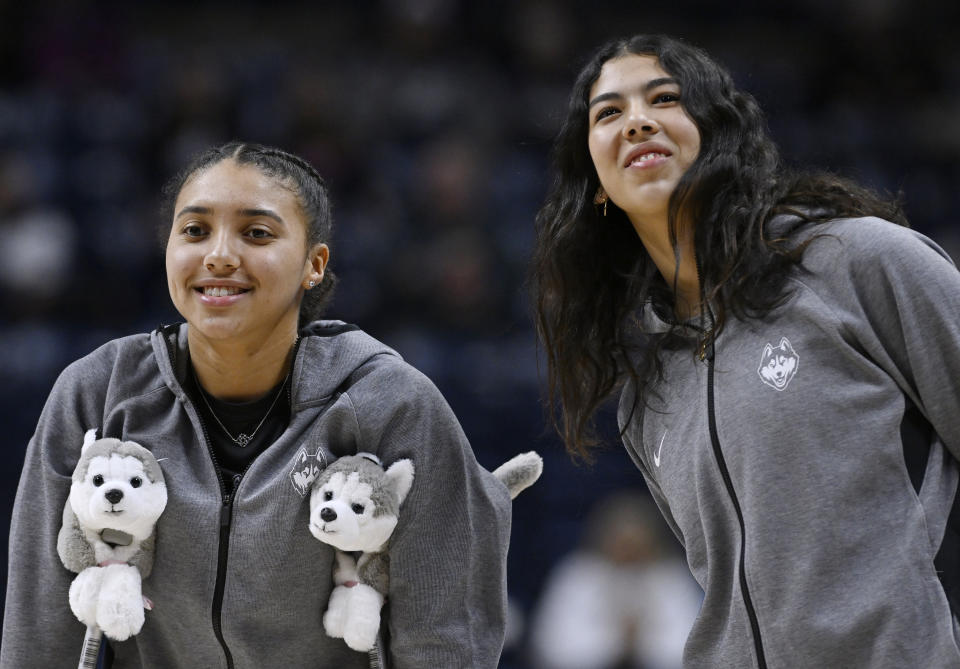 UConn's Azzi Fudd, left, and newest addition to the team Jana El Alfy, right, of Egypt, watch their team warm up before an NCAA college basketball game against DePaul, Monday, Jan. 23, 2023, in Storrs, Conn. (AP Photo/Jessica Hill)