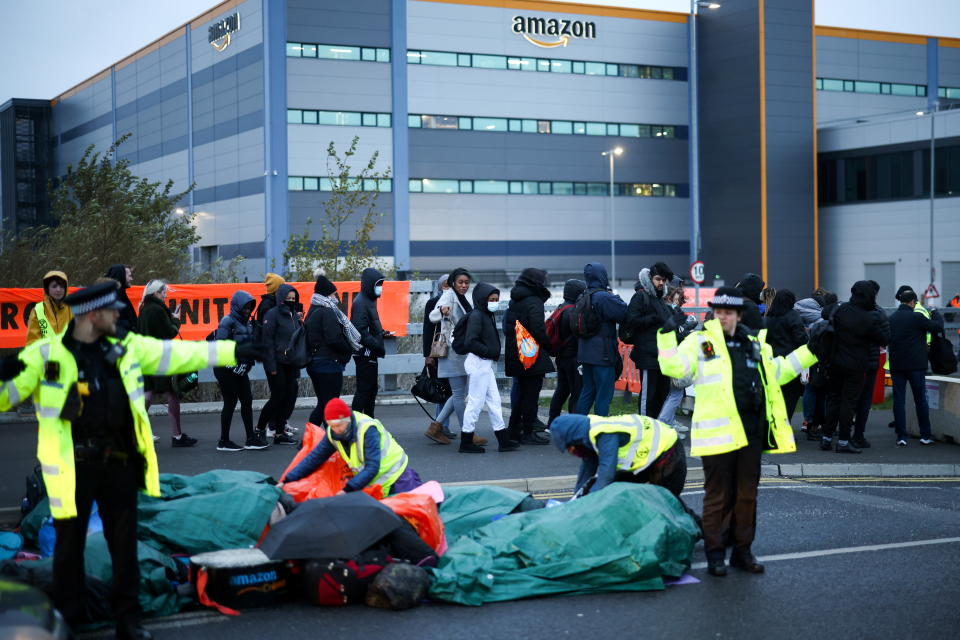 Workers of Amazon enter an Amazon fulfilment centre, as Extinction Rebellion activists protest outside an entrance, in Tilbury, Essex, Britain, November 26, 2021. REUTERS/Henry Nicholls