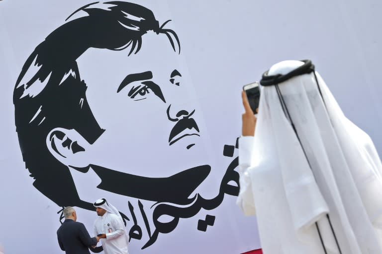 A Qatari takes a photo during the signing of a wall bearing a portrait of Qatar's Emir Sheikh Tamim bin Hamad al-Thani in Doha on July 13, 2017
