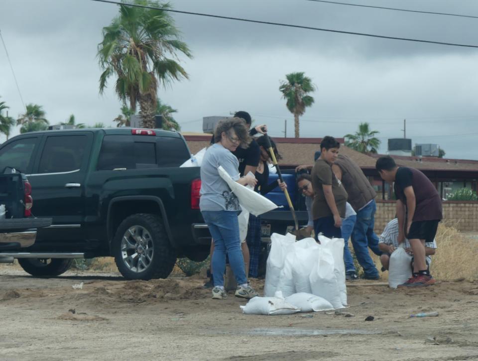 Rain falls as a family fills up sandbags in Hesperia. The tropical storm produced by Hurricane Hilary moved into the High Desert on Sunday. The storm flooded roads, washes, and backyards. It also made everyday life difficult for many.