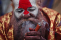 A Hindu holy man smokes marijuana during Shivaratri festival at the premises of Pashupatinath temple in Kathmandu, Nepal, Friday, Feb. 21, 2020. Hindu holy men were joined by devotees and the public Friday at a revered temple in Kathmandu where they lit up marijuana cigarettes during an annual festival despite prohibition and warning by authorities. Hindu holy men were joined by devotees and the public Friday at a revered temple in Kathmandu where they lit up marijuana cigarettes during an annual festival despite prohibition and warning by authorities. “There is a ban on smoking marijuana but at the same time it is centuries-old tradition which we have to respect,”said police officer Suman Khadka adding there was no arrests made Friday. (AP Photo/Niranjan Shrestha)