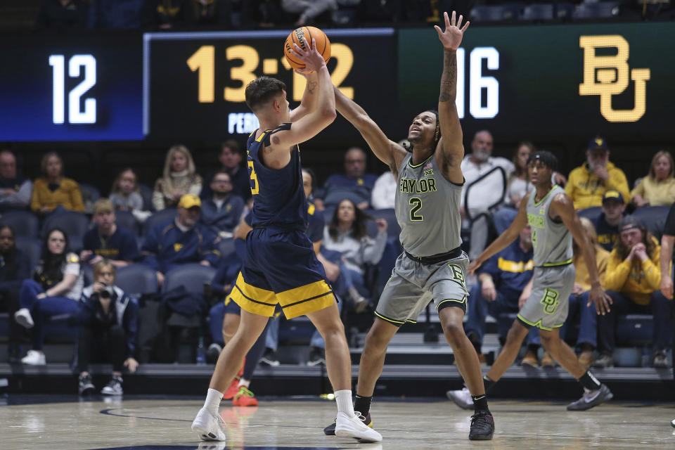 West Virginia guard Kerr Kriisa (3) is defended by Baylor guard Jayden Nunn (2) during the first half of an NCAA college basketball game Saturday, Feb. 17, 2024, in Morgantown, W.Va. (AP Photo/Kathleen Batten)