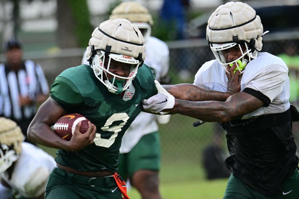 Florida A&M Rattlers running back Kelvin Dean Jr. (9) attempts to avoid defensive back Chase Lloyd with a stiff arm during the team's first scrimmage of fall football training camp at Corry Field in Quincy, Florida, Saturday, Aug. 12, 2023.