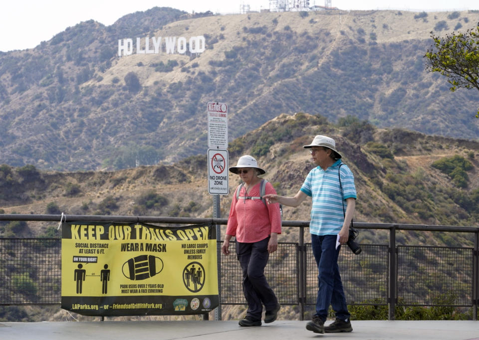 Visitors are seen without face masks at the Griffith Observatory in Los Angeles, Monday, May 17, 2021. California is keeping its rules for wearing face masks in place until the state more broadly lifts its pandemic restrictions on June 15. (AP Photo/Damian Dovarganes)