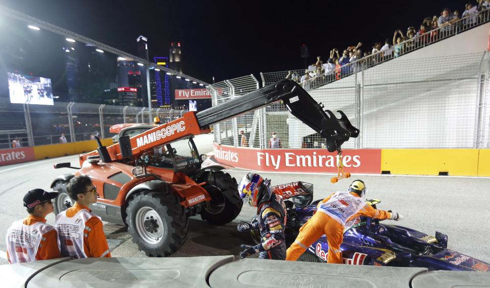 Toro Rosso Formula One driver Daniel Ricciardo of Australia walks away from his crashed car as it is recovered during the Singapore F1 Grand Prix at the Marina Bay street circuit in Singapore September 22, 2013. REUTERS/Natashia Lee (SINGAPORE - Tags: SPORT MOTORSPORT F1)