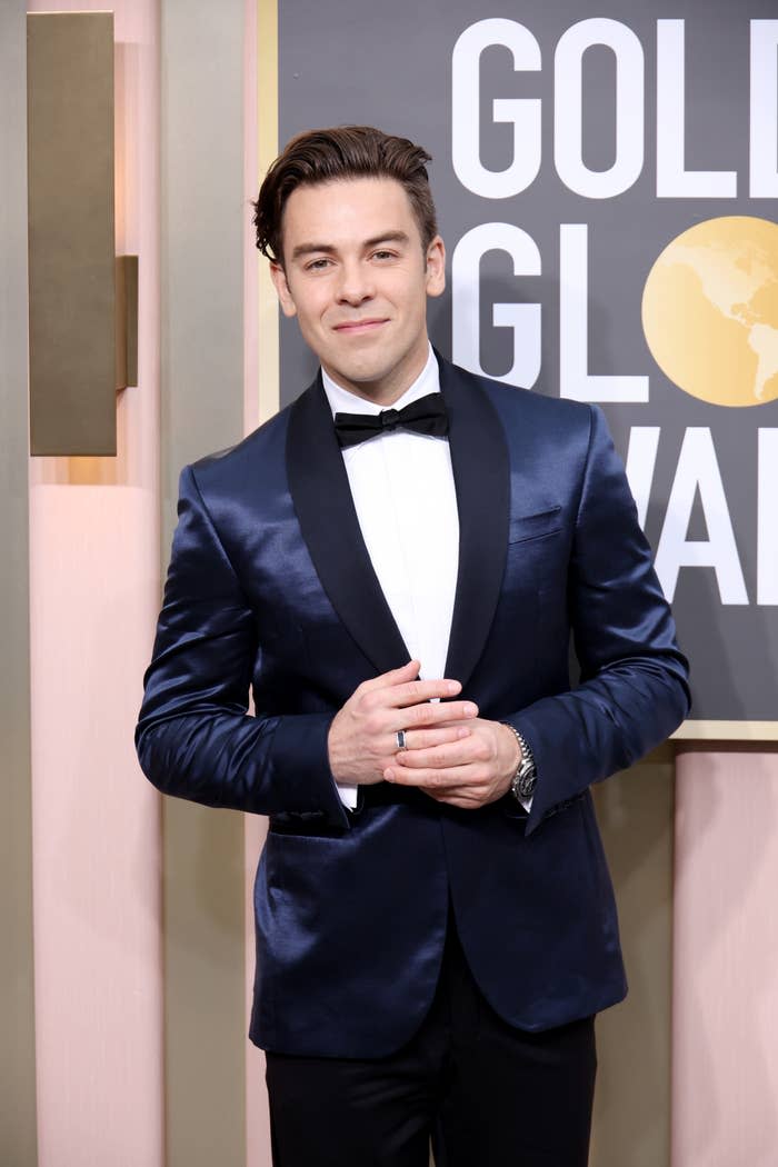 Cody Ko on the red carpet at the Golden Globe Awards. He is wearing a sleek, dark suit with a bow tie