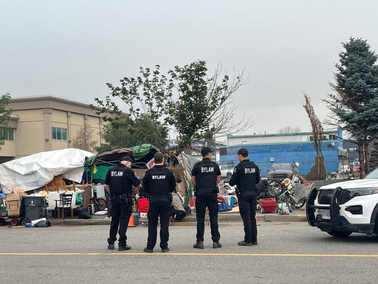 Bylaw officers arrived early Monday morning to enforce the eviction of encampment residents at Millennium Park in Prince George, B.C.  (Kate Partridge/CBC - image credit)