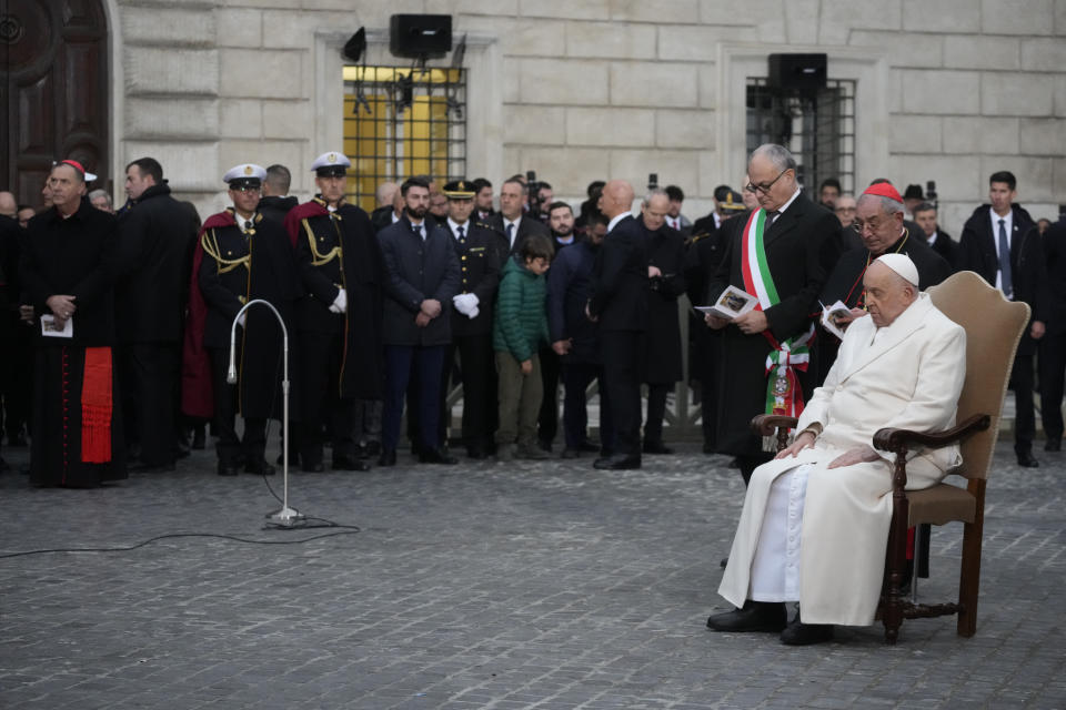 Pope Francis, right, is flanked by, from right, his vicar Cardinal Angelo Comastri, and Rome's Mayor Roberto Gualtieri during his annual Christmas visit to venerate a statue of the Virgin Mary near the Spanish Steps in Rome, Friday, Dec. 8, 2023. (AP Photo/Gregorio Borgia)
