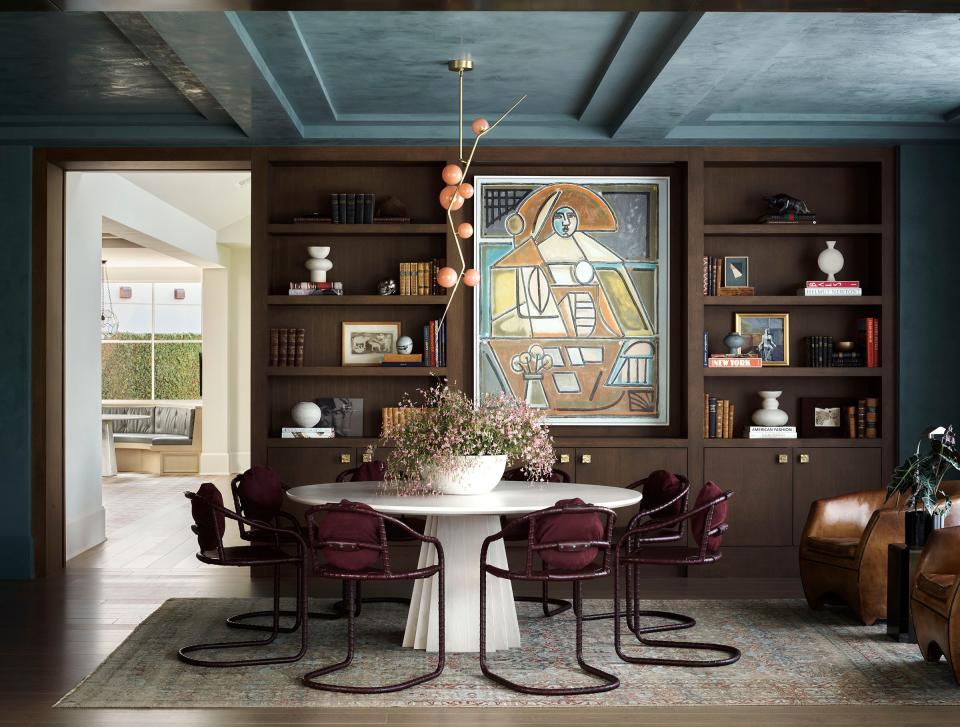 Architect Ryan Street and interior designer Emily Seiders teamed up to build and design this layered, highly detailed home on Lake Austin. In the dining area, which is connected to a bar and a parlor, a bleached white-oak dining table (designed by Seiders) was paired with leather-wrapped burgundy chairs from Ochre. The delicate chandelier, by Lindsey Adelman, has rosy glass globes that match the colors of the nearby parlor.