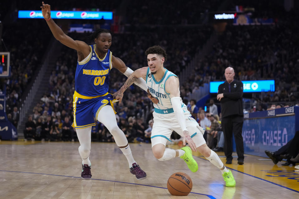 Charlotte Hornets guard LaMelo Ball, right, drives against Golden State Warriors forward Jonathan Kuminga during the first half of an NBA basketball game in San Francisco, Tuesday, Dec. 27, 2022. (AP Photo/Godofredo A. Vásquez)