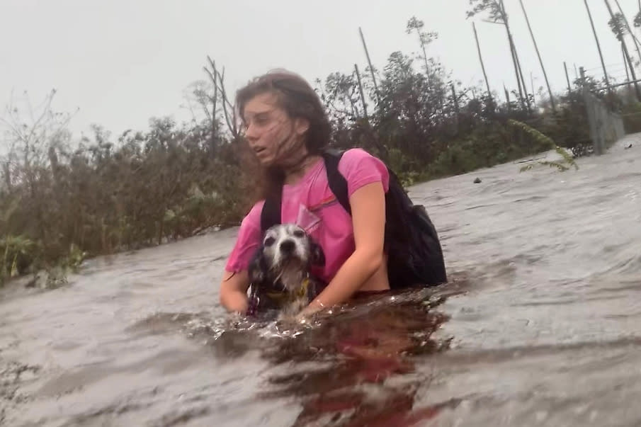 Julia Aylen wades through waist deep water carrying her pet dog as she is rescued from her flooded home during Hurricane Dorian in Freeport, Bahamas, Sept. 3, 2019. (Photo: Tim Aylen/AP)