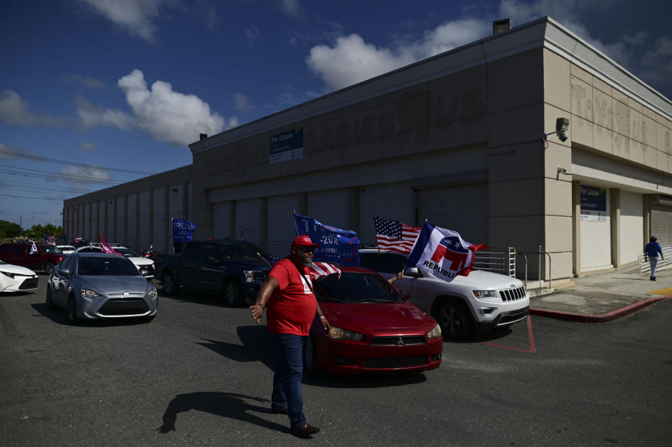 Supporters of president Donald Trump gather moments before leaving for the headquarters of the Republican party in support of his candidacy a few weeks before the presidential election next November, in Carolina, Puerto Rico, Sunday, Oct. 18, 2020. President Donald Trump and former Vice President Joe Biden are targeting Puerto Rico in a way never seen before to gather the attention of tens of thousands of potential voters in the battleground state of Florida. (AP Photo/Carlos Giusti)