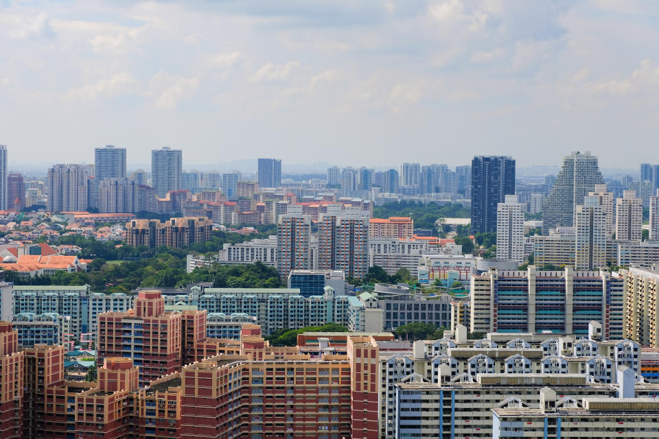 Architectural panoramic shot of Toa Payoh central skyline on a sunny day. Greenery is interspersed among the dense high rise, typically colourful, public housing buildings (HDB flats)