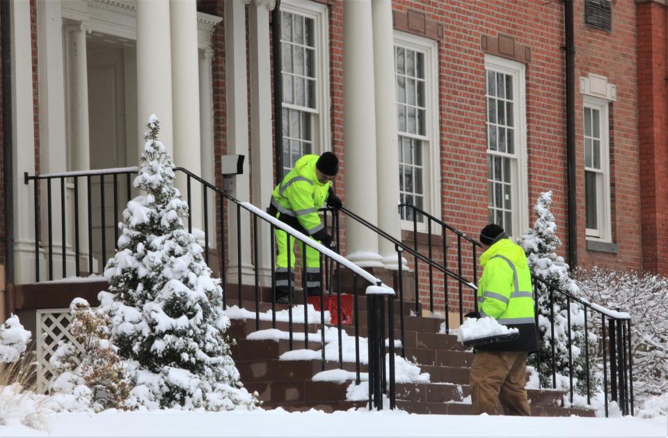 Workers shovel snow off the front steps of the state Superior Courthouse of Morris County in Morristown after snow fell across the region on Tuesday, Feb. 28, 2023.