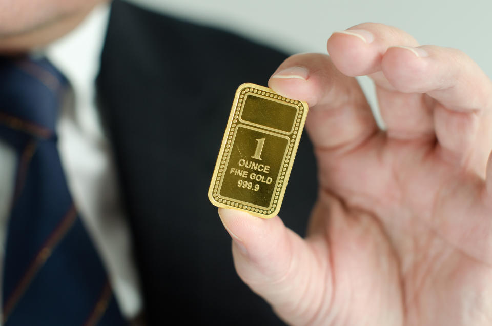 A man holding a gold ingot