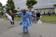 Healthcare workers at New Orleans East Hospital wave handkerchiefs and dance to a jazz serenade, as a tribute for their care of COVID-19 patients, by the New Orleans Jazz Orchestra, outside the hospital in New Orleans, Friday, May 15, 2020. A New York woman collaborated with the New Orleans Jazz Orchestra to put on what she calls a stimulus serenade to give moral support to front-line hospital workers and COVID-19 patients in New Orleans (AP Photo/Gerald Herbert)