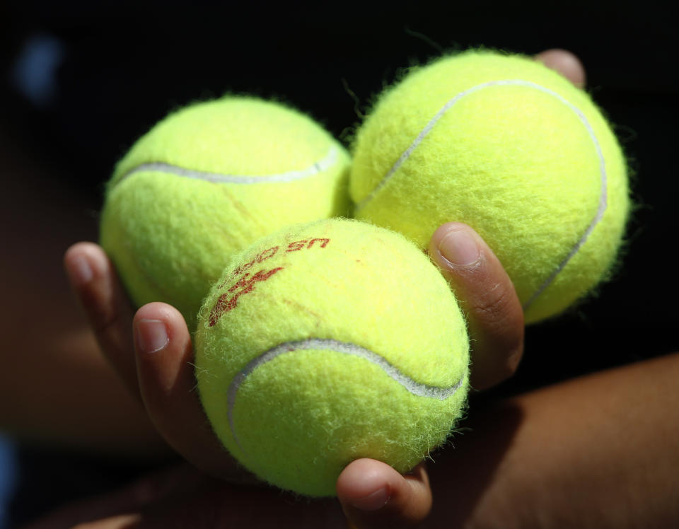 FILE - In this Aug. 30, 2011, file photo, tennis ball are held during the first round of the U.S. Open tennis tournament in New York. The four major pro major sports leagues and the NCAA think that expanding legal betting will lead to more game-fixing. The sport most susceptible to match-fixing or manipulation, however, may be tennis. (AP Photo/Mike Groll, File)