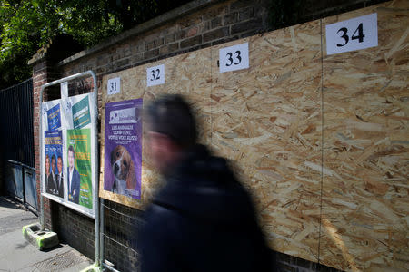 A man walks past official European election posters in a street in Amiens, France, May 16, 2019. REUTERS/Pascal Rossignol