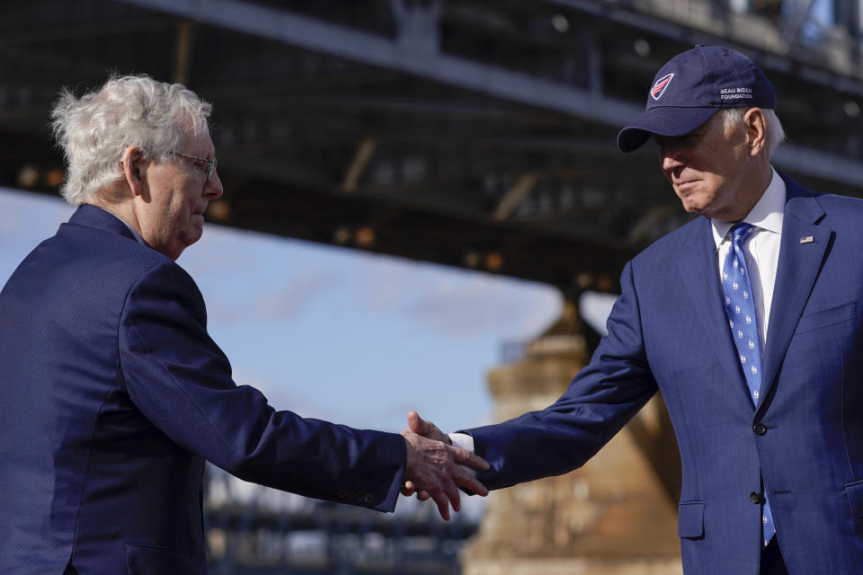 President Joe Biden shakes hands with Senate Minority Leader Mitch McConnell of Ky., after speaking about his infrastructure agenda under the Clay Wade Bailey Bridge, Wednesday, Jan. 4, 2023, in Covington, Ky. Biden's infrastructure deal that was enacted in late 2021 will offer federal grants to Ohio and Kentucky to build a companion bridge that is intended to alleviate traffic on the Brent Spence Bridge, bottom background. (AP Photo/Patrick Semansky)