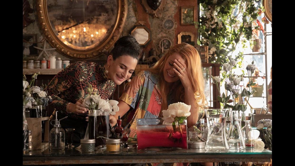 a man and woman sitting at a table with flowers