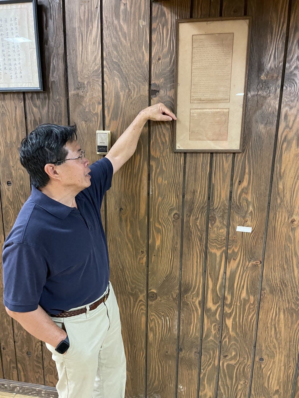 Gary Tom, president of Augusta's Chinese Consolidated Benevolent Association, points out the group's original 1927 petition founding the CCBA, at the group's downtown headquarters on Walker Street.