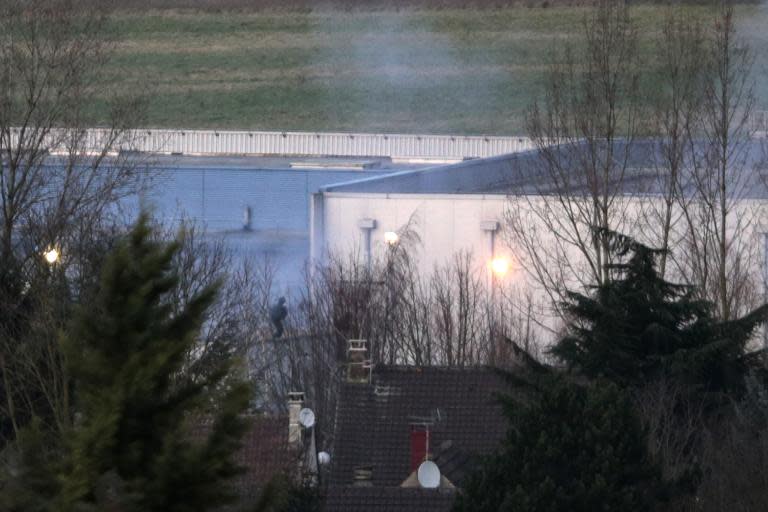 Police officers launch an assault as smoke rises from a building in Dammartin-en-Goele, northeast of Paris