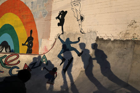 FILE PHOTO: Members of Gaza Skating Team cast shadows as they practice their rollerblading and skating skills at the seaport of Gaza City March 8, 2019. REUTERS/Mohammed Salem