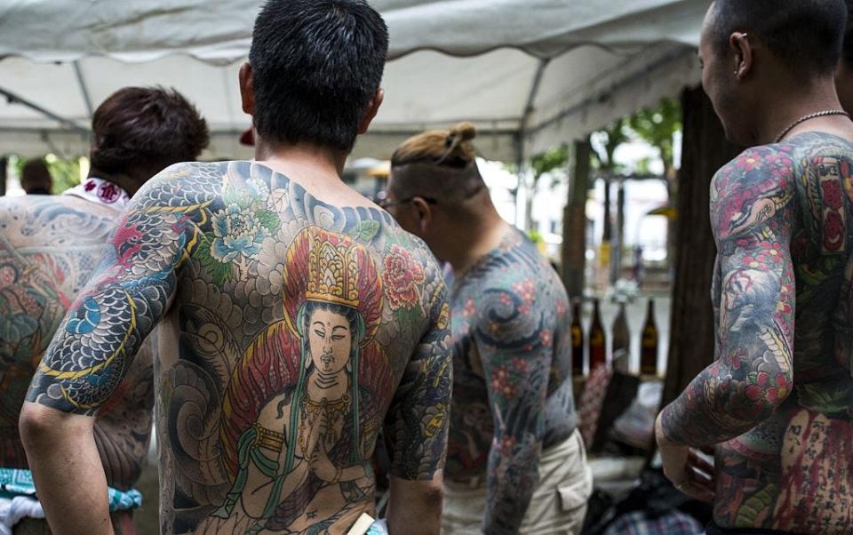 Yakuza members display their tattoos during the second day of the Sanja Matsuri Festival in Tokyo's Asakusa district on May 14, 2016.