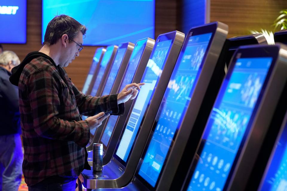 Shawn Harnish, of Boston, places a sports bet at a kiosk at Encore Boston Harbor casino Tuesday in Everett. Massachusetts sports fans who want to wager on their favorite teams are finally getting their chance as the state kicks off sports betting at casinos in the state beginning Tuesday.