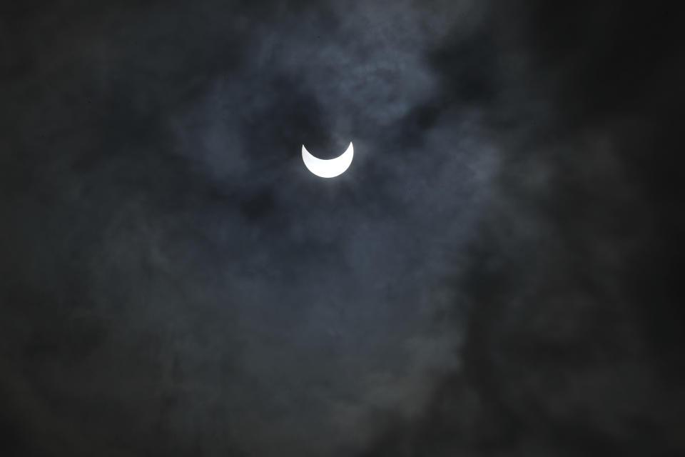 The sun is seen through rain clouds during solar eclipse in Ahmedabad, India, Sunday, June 21, 2020. (AP Photo/Ajit Solanki)