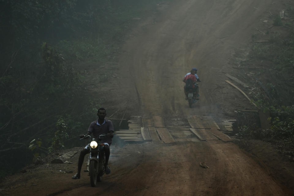 Residents motorcycle amid smoke from forest fires at dawn in the Vila Nova Samuel region, along the road to the National Forest of Jacunda, near the city of Porto Velho, Rondonia state, part of Brazil's Amazon, Aug. 25, 2019. (Photo: Eraldo Peres/AP)