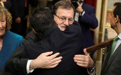 Spain's Prime Minister Mariano Rajoy embraces a party deputy at Parliament - Credit: SERGIO PEREZ/Reuters