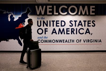 FILE PHOTO: An international passenger arrives at Washington Dulles International Airport after the U.S. Supreme Court granted parts of the Trump administration's emergency request to put its travel ban into effect later in the week pending further judicial review, in Dulles, Virginia, U.S.,on June 26, 2017. REUTERS/James Lawler Duggan/File Photo