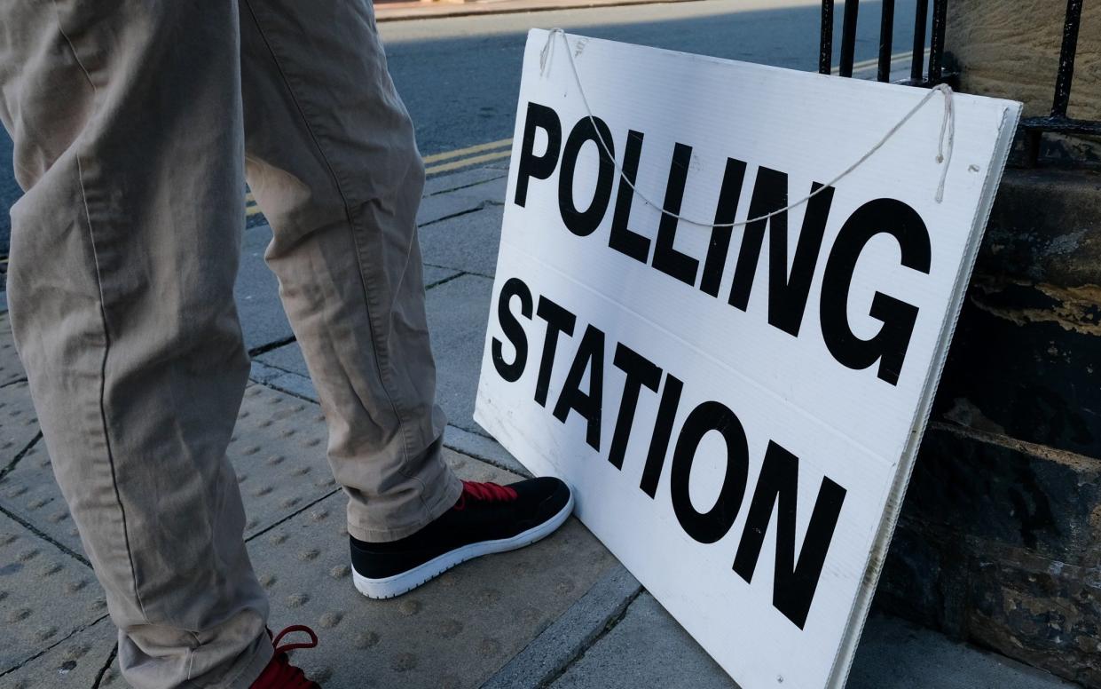 A polling station official prepares to attach a sign outside a polling station during local elections on May 02, 2019 in Saltburn By The Sea, United Kingdom. - Ian Forsyth/Getty Images