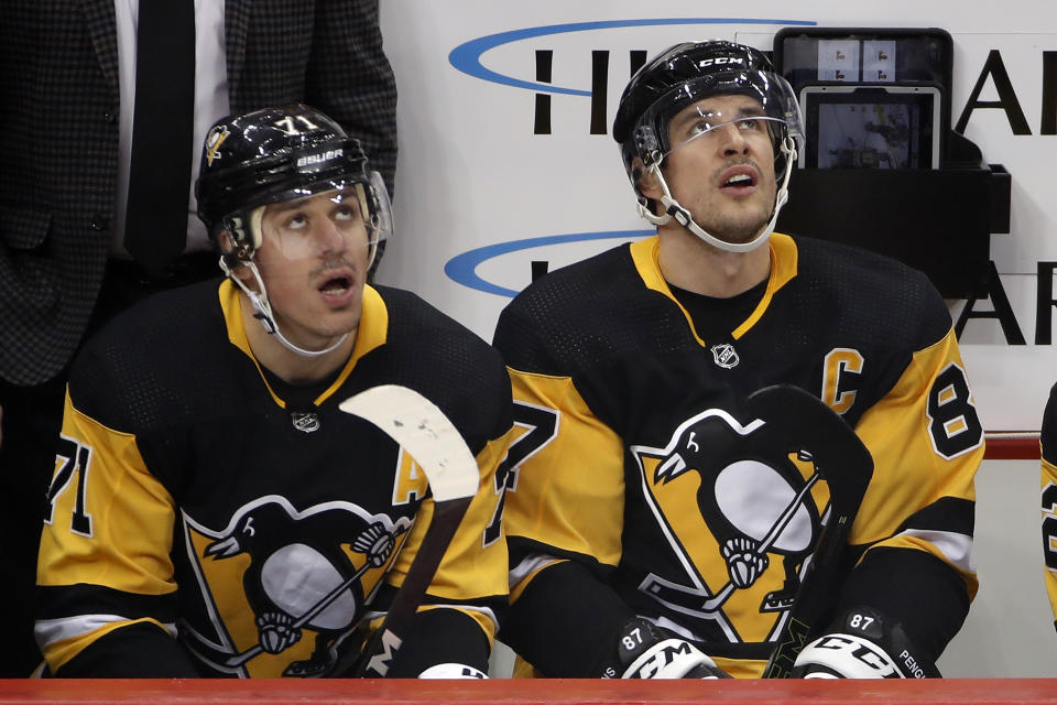 Pittsburgh Penguins' Evgeni Malkin (71) and Sidney Crosby (87) watch a replay of a goal by Malkin during the first period of the team's NHL hockey game against the Minnesota Wild in Pittsburgh, Tuesday, Jan. 14, 2020. (AP Photo/Gene J. Puskar)