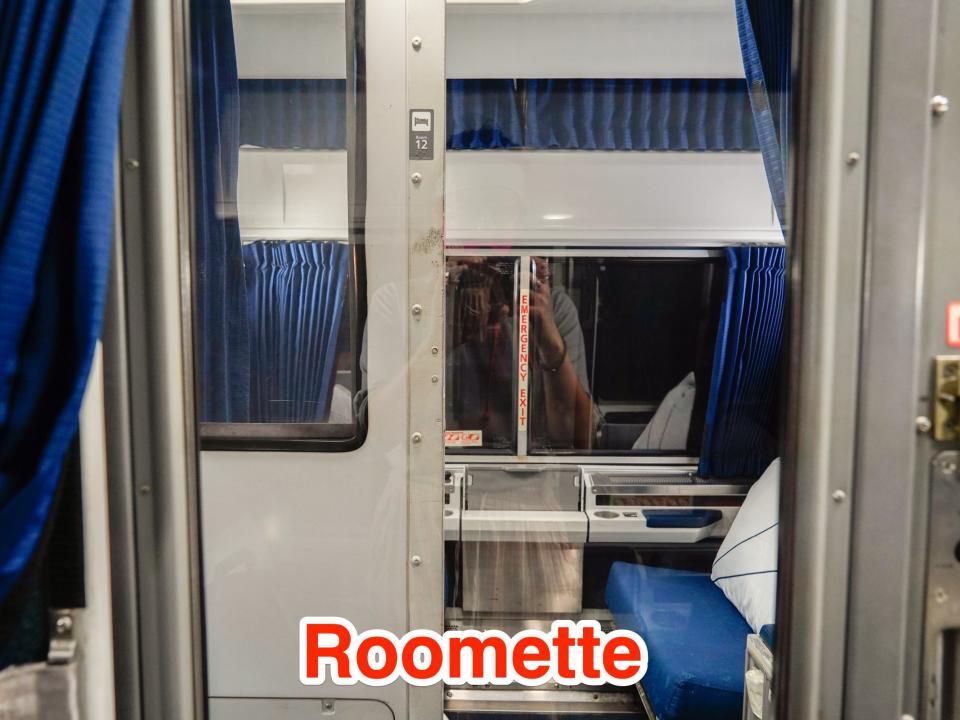 A roomette is seen across the way from another roomette with the door half open