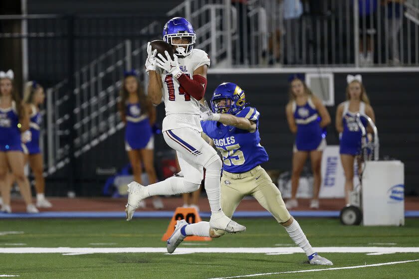 MISSION VIEJO, CA - SEPTEMBER 17: Makai Lemon, 14, of Los Alamitos, catches a touchdown pass thrown by quarterback Malachi Nelson (7) defended by Christian Laliberte (25), of Santa Margarita, in the first half at Saddleback College Stadium on Friday, Sept. 17, 2021 in Mission Viejo, CA. (Gary Coronado / Los Angeles Times)