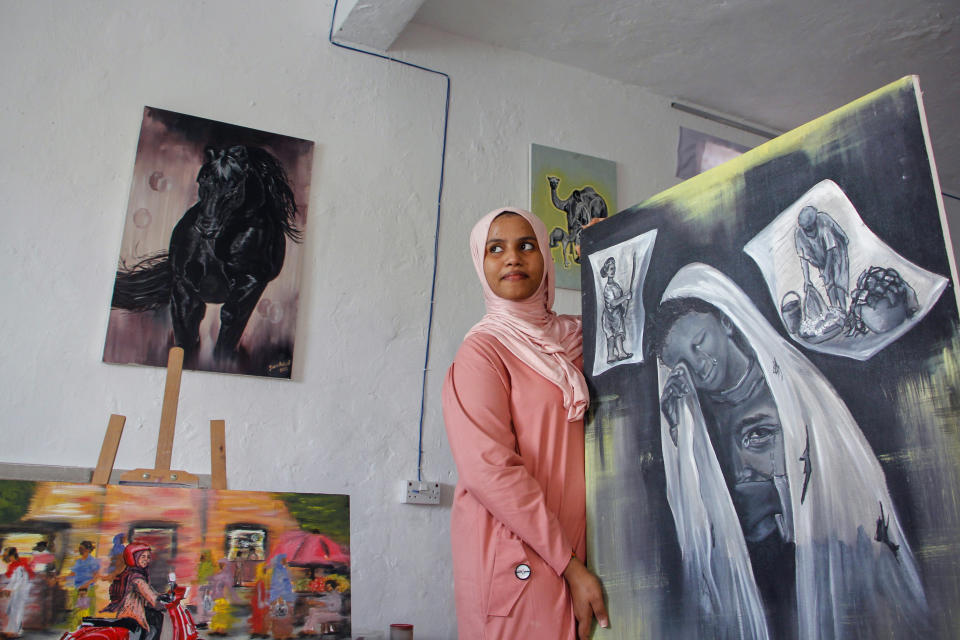 Somali artist Sana Ashraf Sharif Muhsin, 21, displays some of her paintings at her home in the capital Mogadishu, Somalia Friday, Oct. 15, 2021. Among the once-taboo professions emerging from Somalia's decades of conflict and Islamic extremism is the world of arts, and this 21-year-old female painter has faced more opposition than most. (AP Photo/Farah Abdi Warsameh)