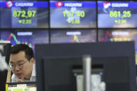 A currency trader watches monitors at the foreign exchange dealing room of the KEB Hana Bank headquarters in Seoul, South Korea, Wednesday, April 29, 2020. Asian stock markets gained Wednesday after France and Spain joined governments that plan to ease anti-virus controls and allow businesses to reopen. (AP Photo/Ahn Young-joon)