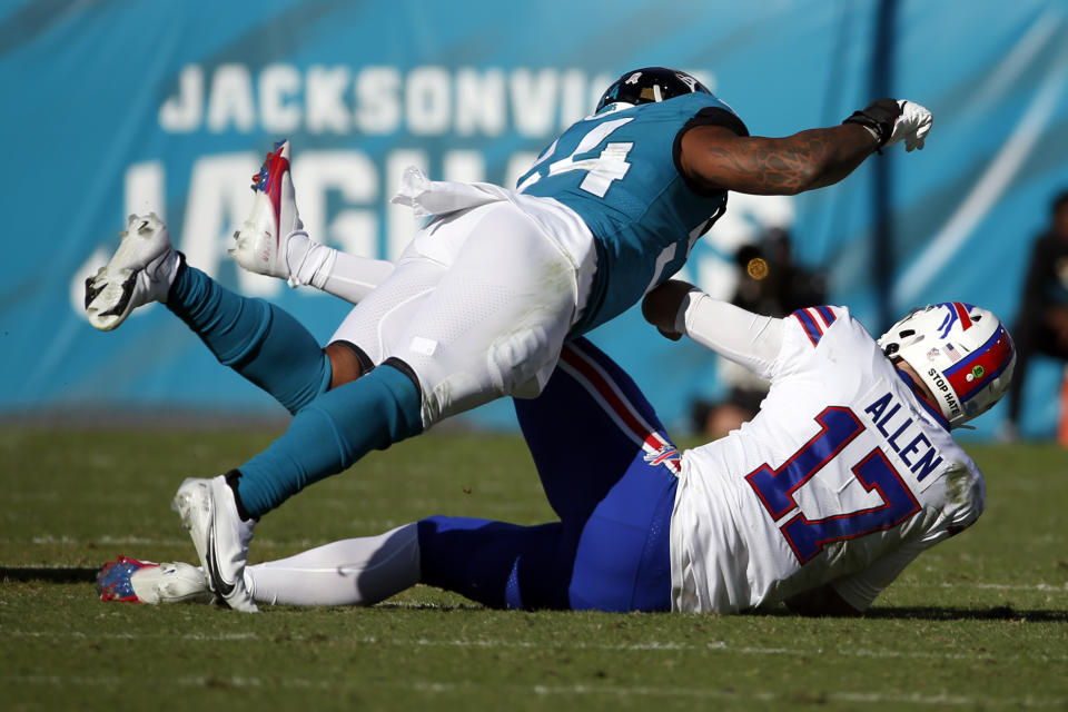 Jacksonville Jaguars linebacker Damien Wilson, left, tackles Buffalo Bills quarterback Josh Allen (17) during the second half of an NFL football game, Sunday, Nov. 7, 2021, in Jacksonville, Fla. (AP Photo/Stephen B. Morton)