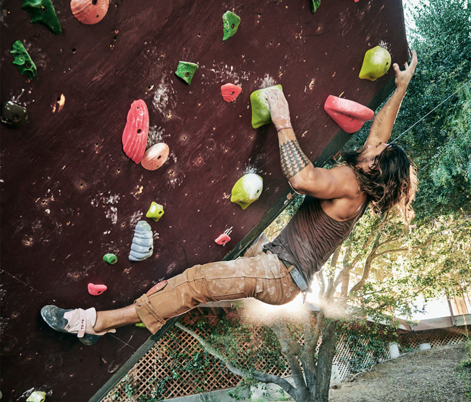 Jason Momoa climbing on outdoor wall at home.<p>Jeff Lipsky for Men's Journal</p>