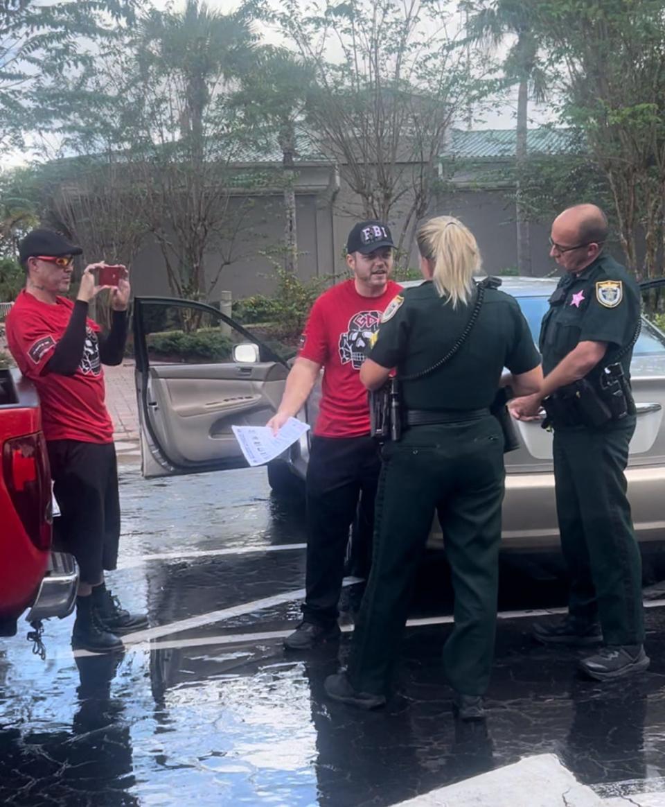 Two men wearing shirts with Nazi symbols talk to deputies Tuesday outside the Space Coast Convention Center in Cocoa after State Rep. Randy Fine said he was accosted by a man who identified himself as a member of an anti-Jewish hate group.