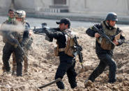 An Iraqi special forces soldier fires as other soldiers run across a street during a battle in Mosul, Iraq March 1, 2017. REUTERS/Goran Tomasevic