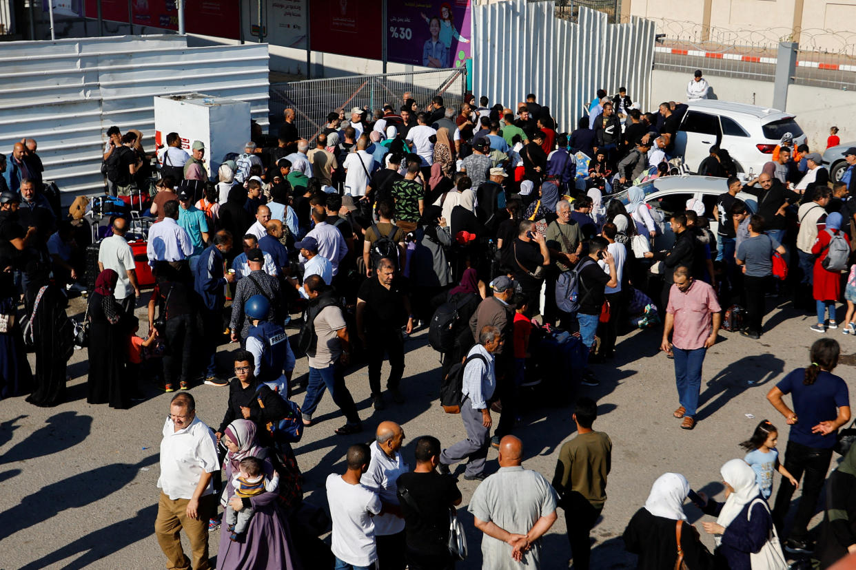 Palestinians with dual citizenship gather outside Rafah border crossing with Egypt in the hope of getting permission to leave Gaza, amid the ongoing Israeli-Palestinian conflict, in Rafah in the southern Gaza Strip October 16, 2023. REUTERS/Ibraheem Abu Mustafa