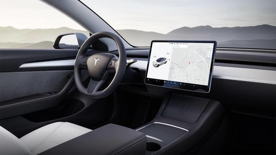 The dashboard of a Tesla Model 3 is dominated by a large tablet-like touchscreen.