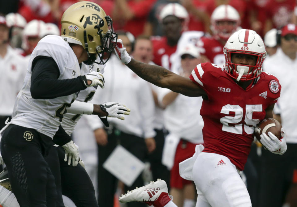 Nebraska running back Greg Bell (25) stiff-arms Colorado defensive backs Delrick Abrams Jr. (1) and Dante Wigley (4) during the first half of a game in 2018. (AP)