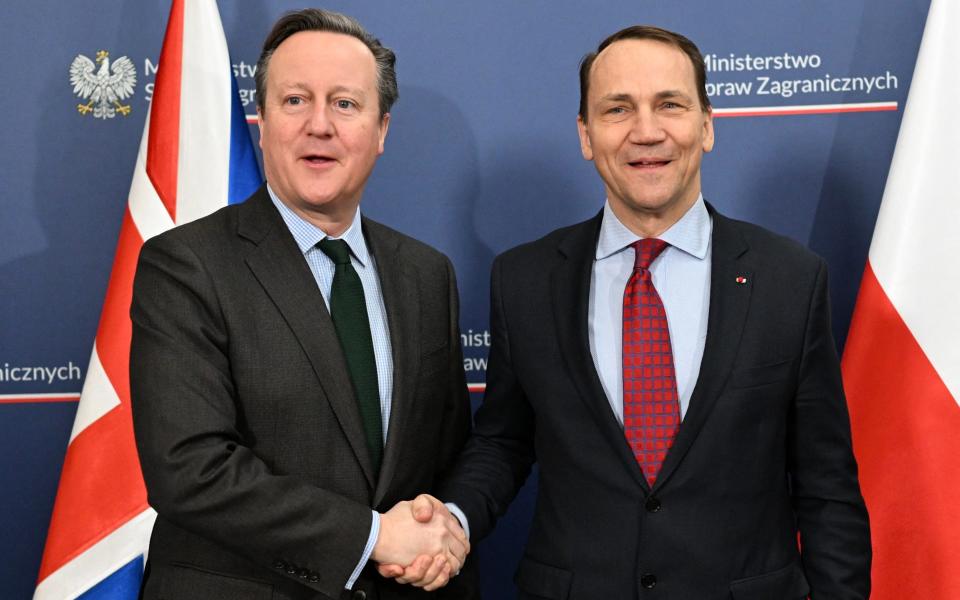 Britain's Foreign Secretary Lord Cameron (L) greets Polish Minister of Foreign Affairs Radoslaw Sikorski (R) in Warsaw at a meeting to shore up support for Ukraine