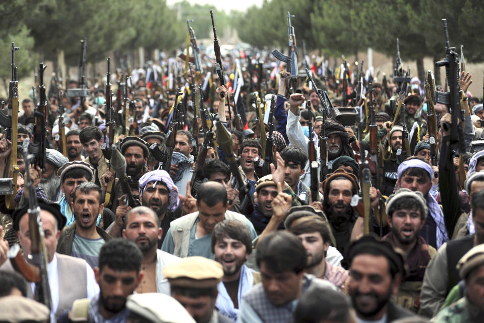 FILE - In this June 23, 2021 file photo, Afghan militiamen join Afghan defense and security forces during a gathering to mobilize local militias across the country to try to stem the tide of the latest Taliban gains, in Kabul, Afghanistan. In an interview with The Associated Press Thursday, July 22, 2021, Suhail Shaheen, Afghan Taliban spokesman and a member of the Taliban negotiation team, said the insurgent movement does not want to monopolize power, but there won't be peace until there is a new, negotiated government in Kabul and Afghan President Ashraf Ghani is removed. Shaheen said women will be allowed to work, go to school, and participate in politics but will have to wear the hijab, or headscarf. (AP Photo/Rahmat Gul, File)