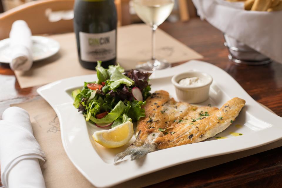 Salumeria 104's Branzino: Broiled Butterfly Branzino served with mixed Greens and Tartar sauce.